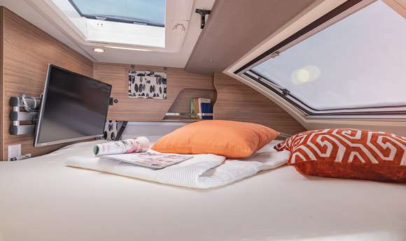 Interieur im TOURER VAN mit Slide-Bett mit großem Panoramafenster und SMART TV-Gerät mit HD-Tuner