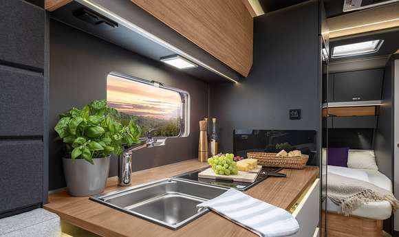 Küche mit Ambientebeleuchtung, edler Arbeitsplatte und Kühlschrank im AZUR